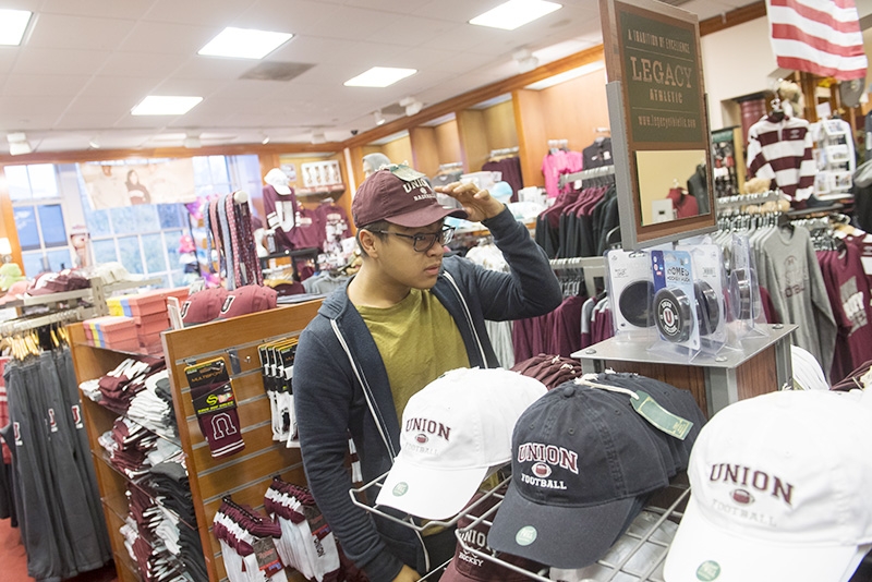 Trying on a hat for sale in the Union College Bookstore