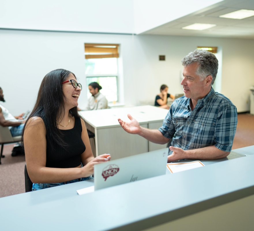 A career center employee and a student speaking at the career center