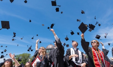 Graduates toss hat into the air