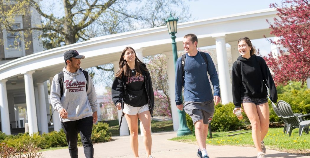 Four students walking through campus